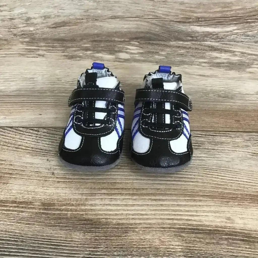 Front view of black Robeez leather baby Velcro sneakers (3-6 months) showing Velcro straps and blue side stripes on wooden floor