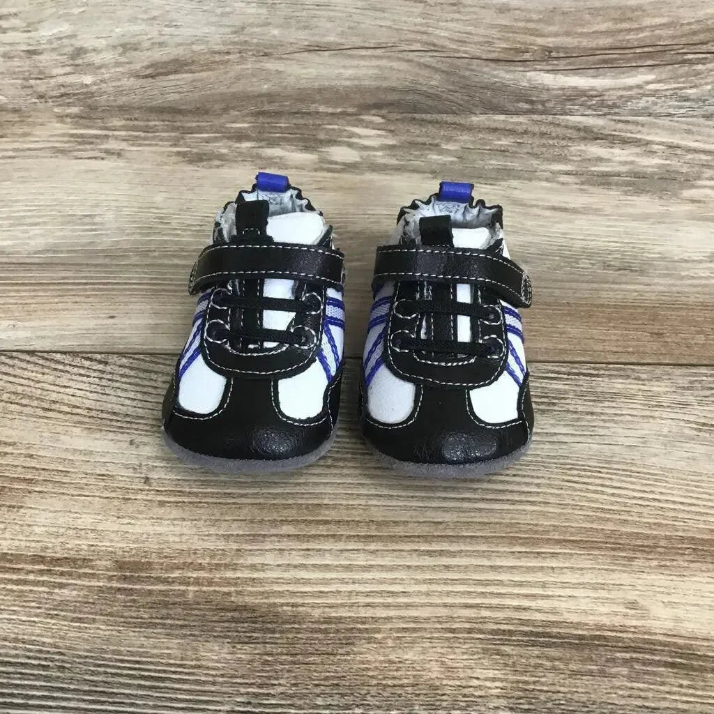 Front view of black Robeez leather baby Velcro sneakers (3-6 months) showing Velcro straps and blue side stripes on wooden floor