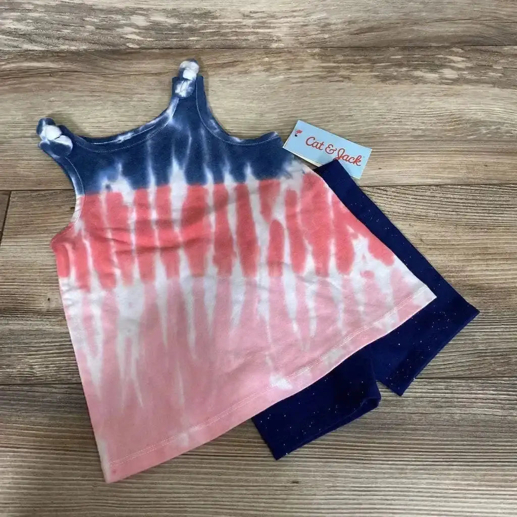 Flat lay of Cat and Jack toddler set: pink and blue tie-dye tank with knotted straps and navy glitter shorts on wood
