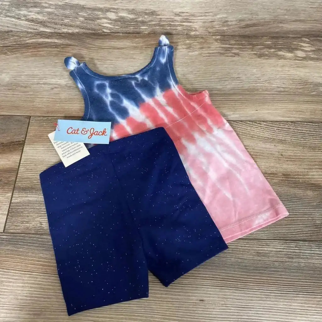 Flat lay of Cat & Jack toddler tank top and shorts showcasing red, white and blue tie-dye tank with navy glitter shorts on wood floor
