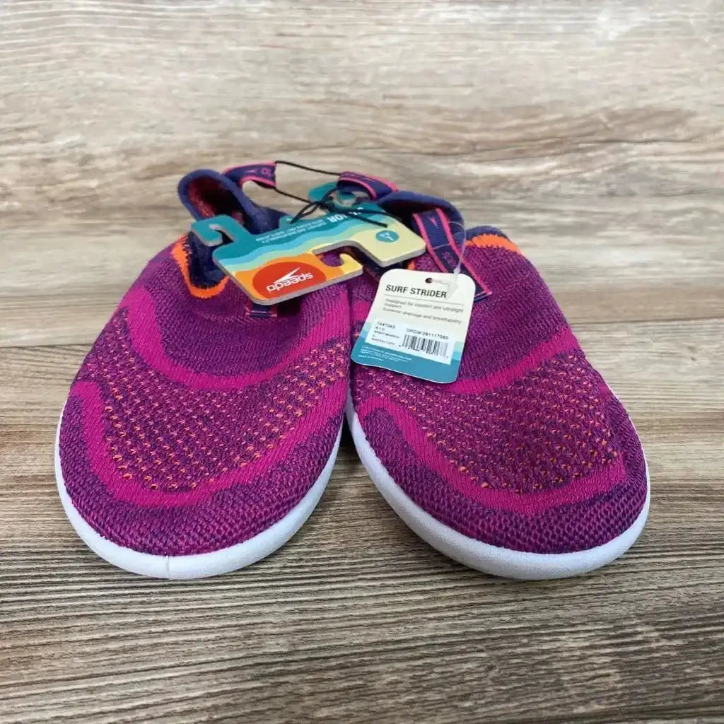 Front view of Speedo Junior Surf Strider water shoes in fuchsia, knit slip-on upper and white sole, size 4/5Y on wood floor