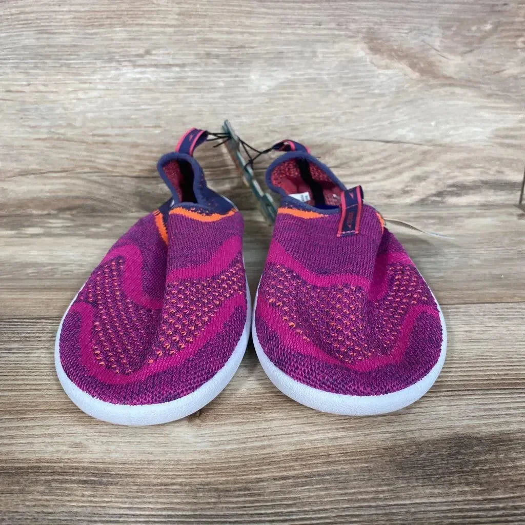 Front view of Speedo Junior Surf Strider water shoes in fuchsia knit with white soles on wooden background