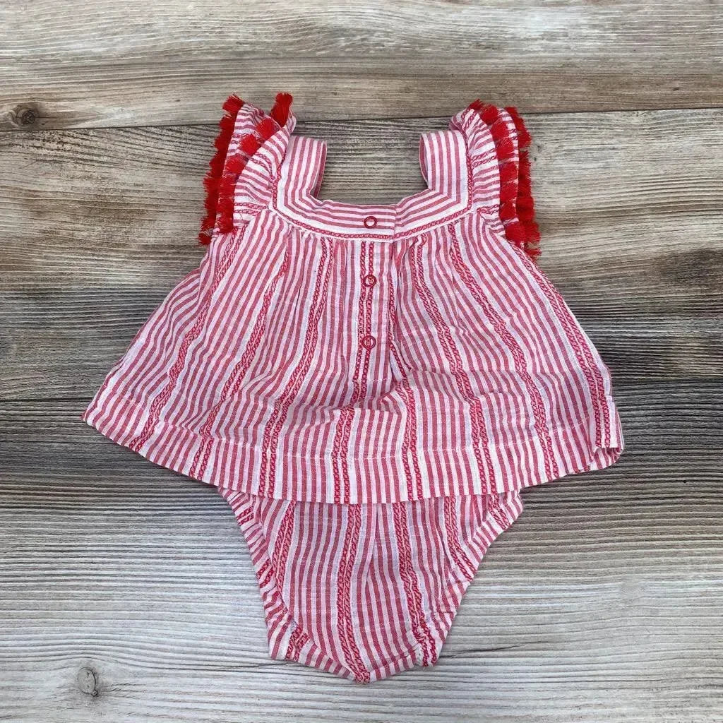 Flat lay of Cat and Jack red-and-white striped newborn romper with tassel-trim ruffled sleeves on wood background