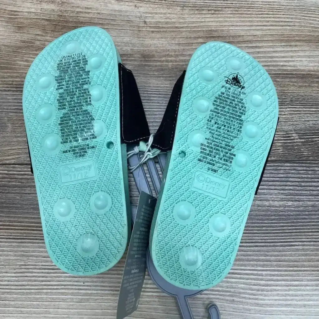 Bottom view of Disney Mickey Mouse slide sandals with mint-green soles, molded size 11/12, black straps on wood