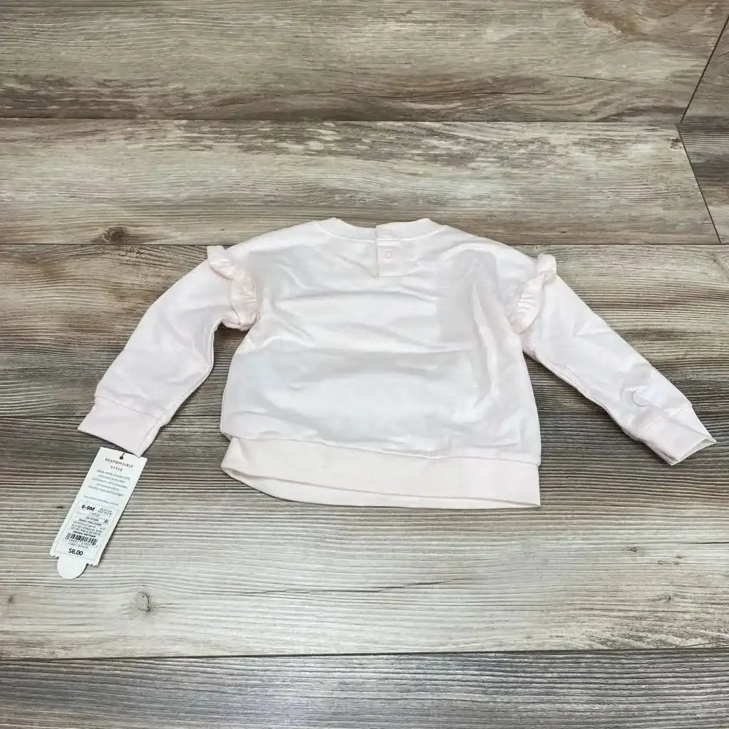 Back view of Cat & Jack pink baby sweatshirt (6–9 months) showcasing ruffle shoulder details and back snap on wood floor background