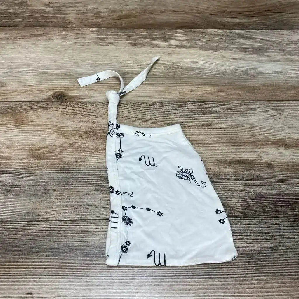 Flat lay of Kate Quinn Scorpio elf hat in cream with black scorpion and zodiac print and pointed tip on wood plank floor