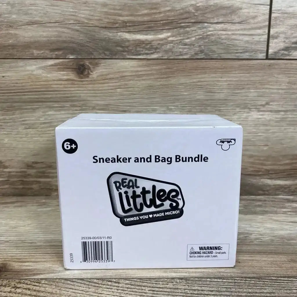 Front of Real Littles Sneaker and Bag Bundle box showing headline Sneaker and Bag Bundle, logo and 6 plus badge on wood floor
