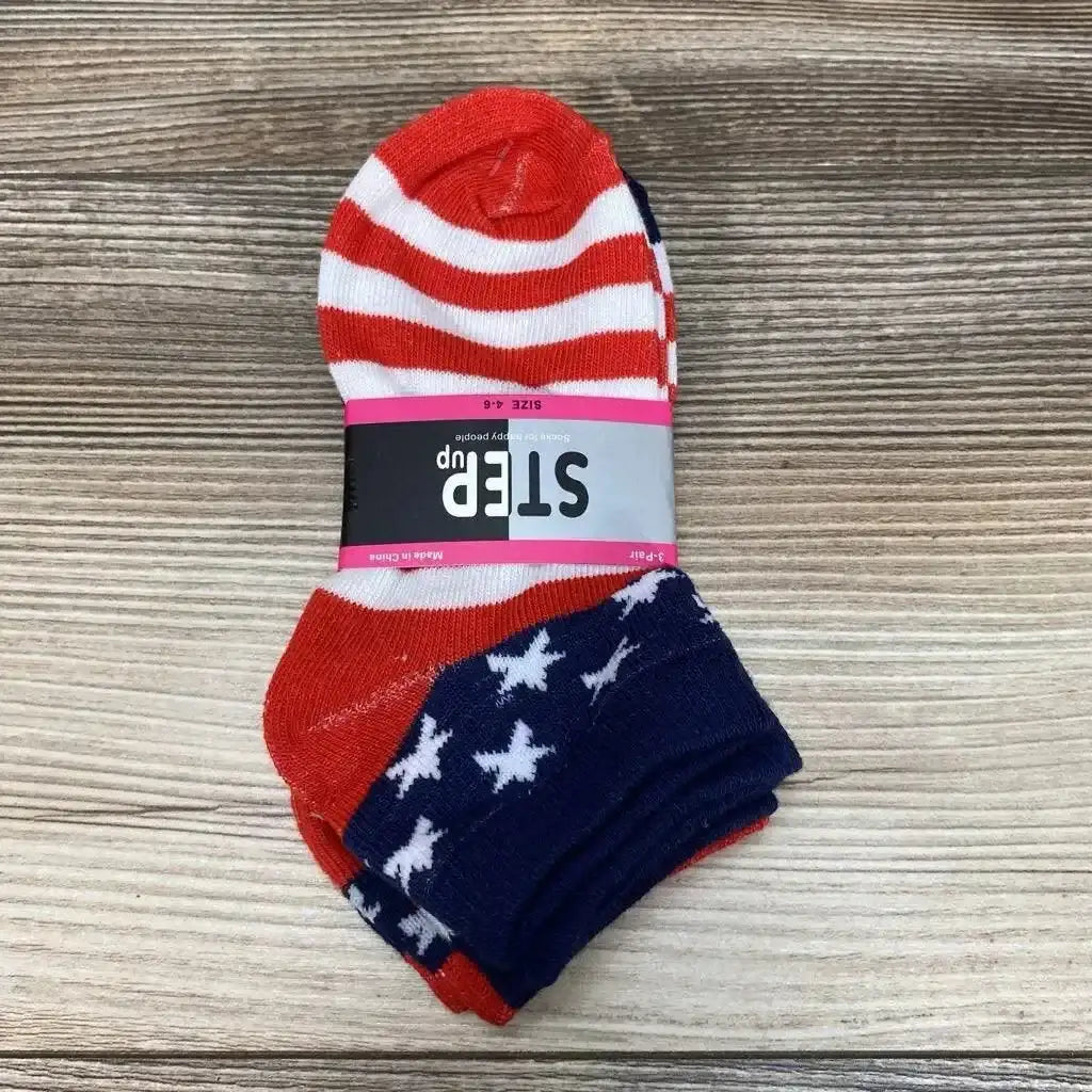 Top view of three-pack baby socks with red and white stripes and navy star pattern on wood background