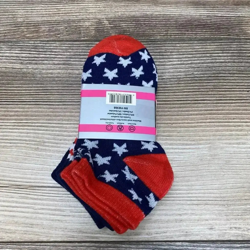 Front view of Step Up pattern socks three pack in navy with white star print and red heel and toe in original packaging on wood plank floor