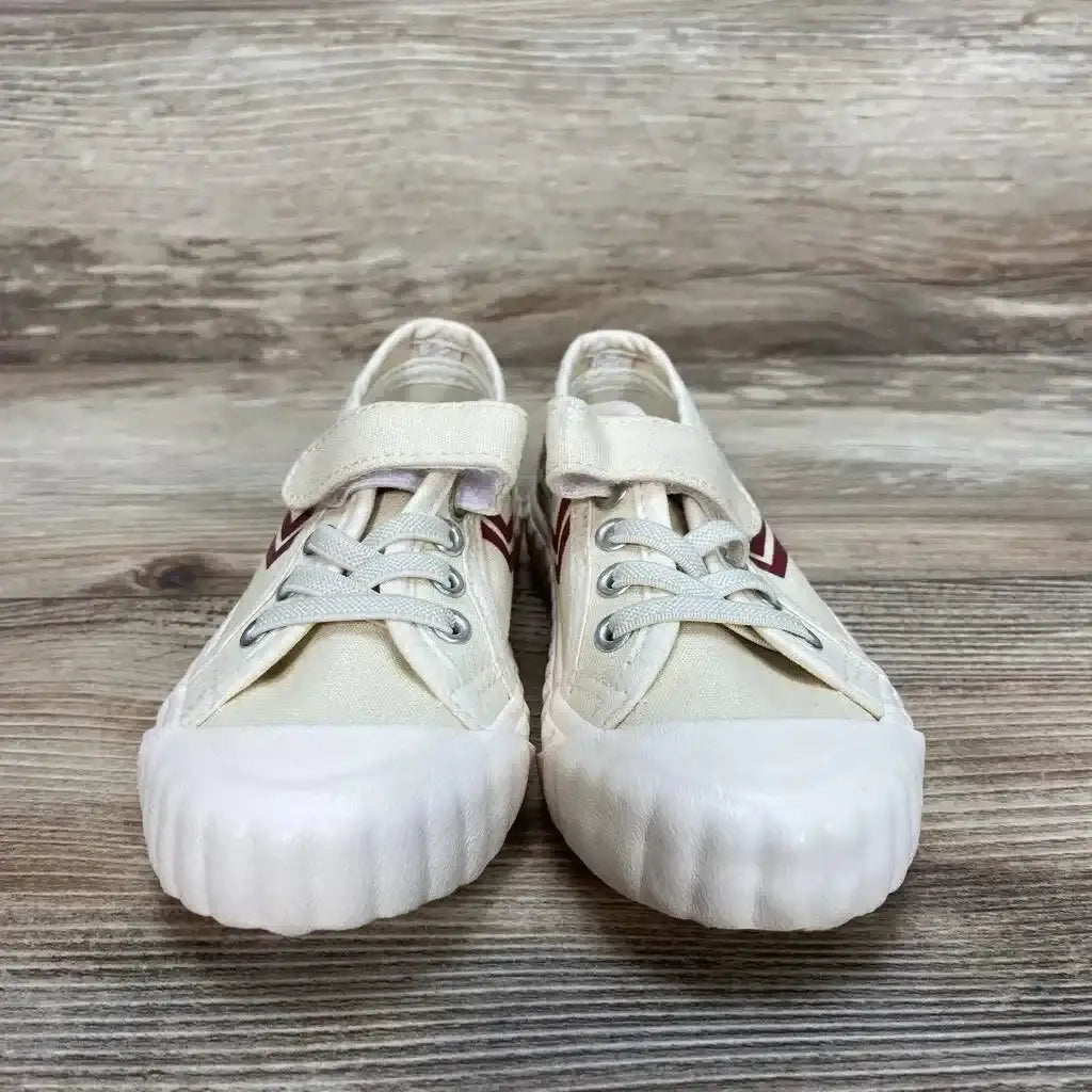 Front view of tan Feiyue Fe Lo toddler sneaker size 7.5C showing velcro strap, red chevron and ribbed white toe on wood