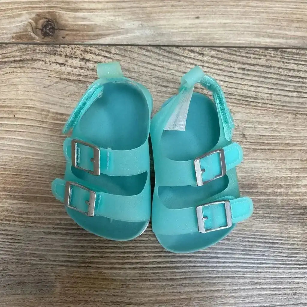 Side view of teal newborn Carter’s jelly sandals showing buckle strap and textured sole on white background