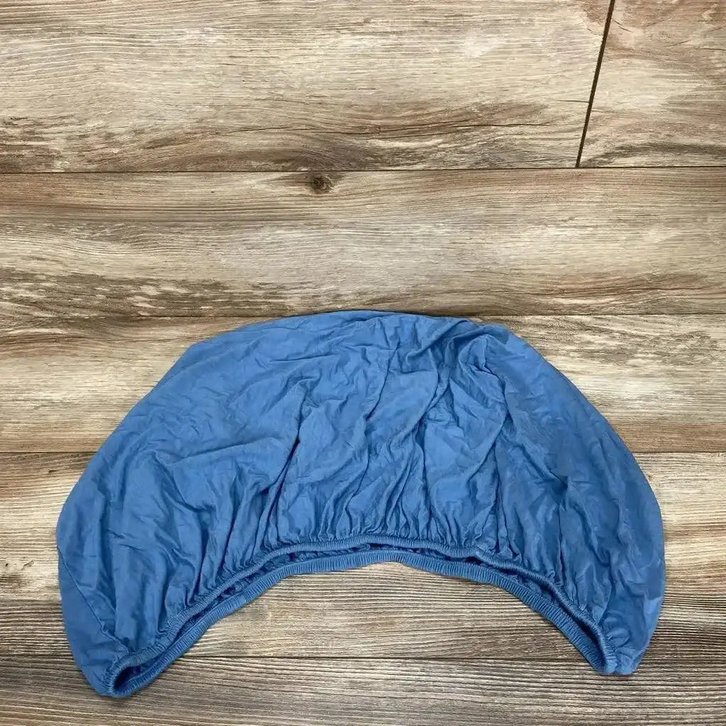 Top-down view of Birdie Bean changing pad cover in river blue showing elastic fitted edge and wrinkled fabric on wood floor
