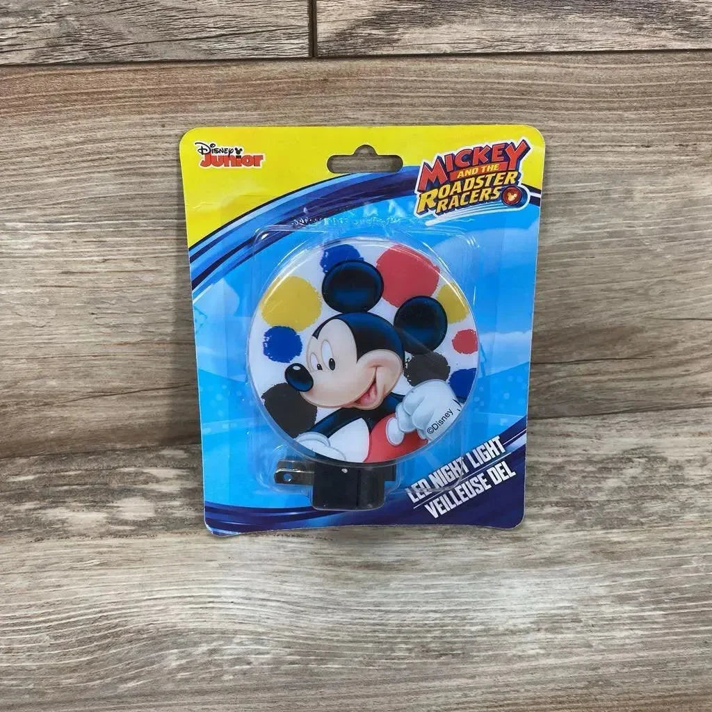Front view of Disney Junior Mickey Mouse LED night light showing round Mickey graphic and on/off plug on wood tabletop