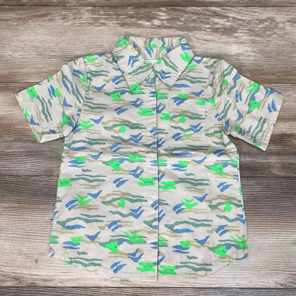 Flat lay of beige 4T Miki Miette button-front short-sleeve shirt showing blue and neon green abstract print on wood floor