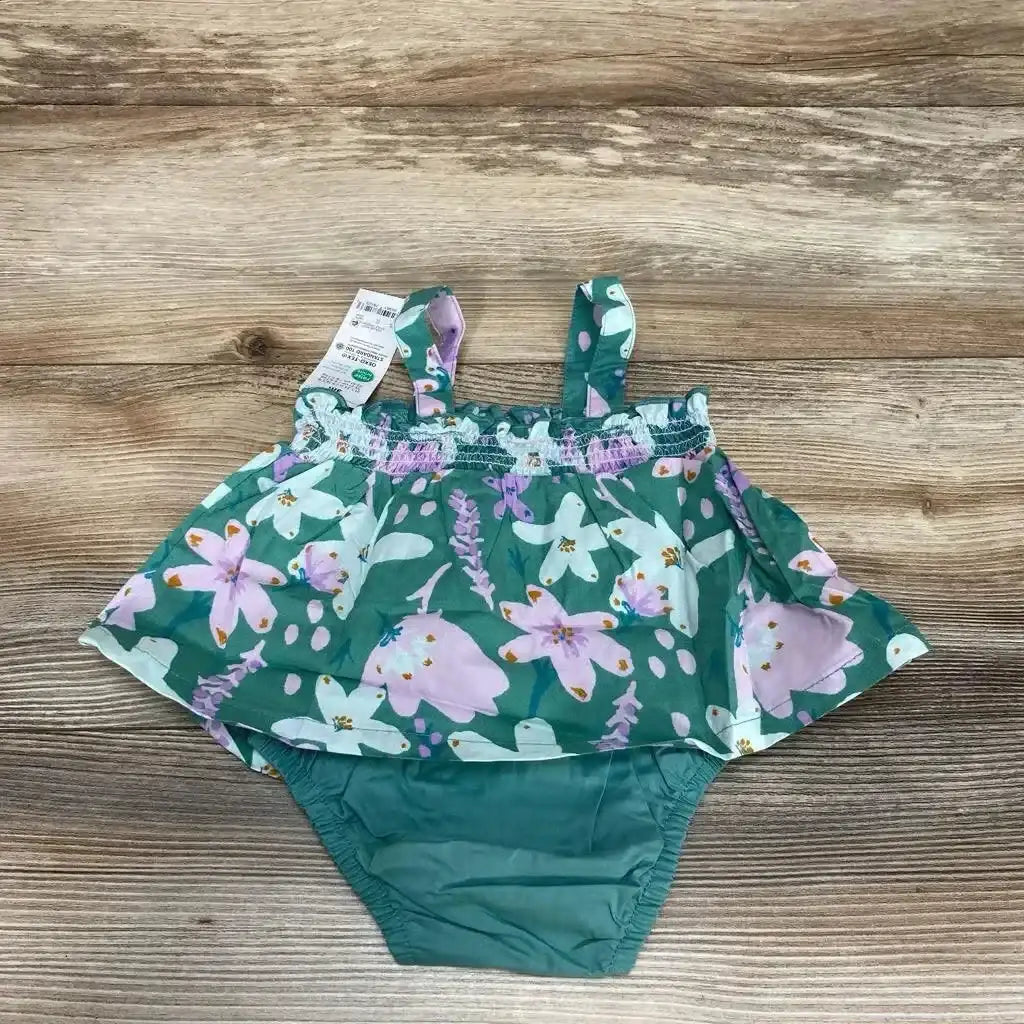 Flat lay of new Just One You green floral print smocked bodysuit dress with attached bloomer and hangtag on wood plank floor