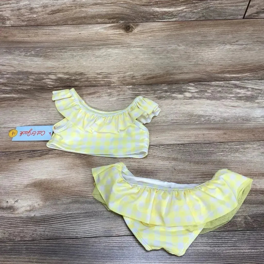 Flat lay of Cat and Jack 2-piece toddler bikini, size 2T, yellow gingham with ruffled top and bottoms on wood background