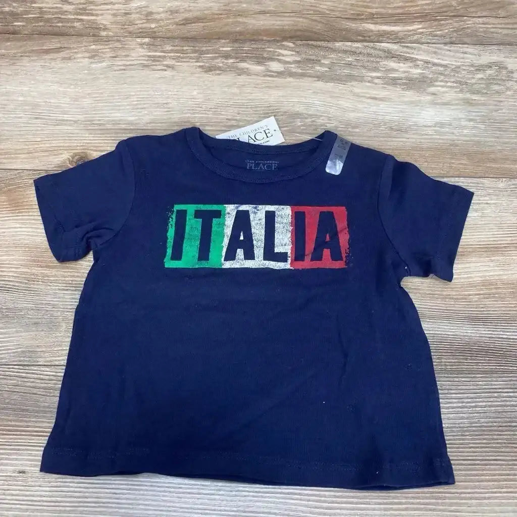 Flat lay of NEW Childrens Place Italia Graphic T-Shirt size 12m showcasing navy short sleeve tee with Italian flag Italia chest print and hangtag on wood plank backdrop