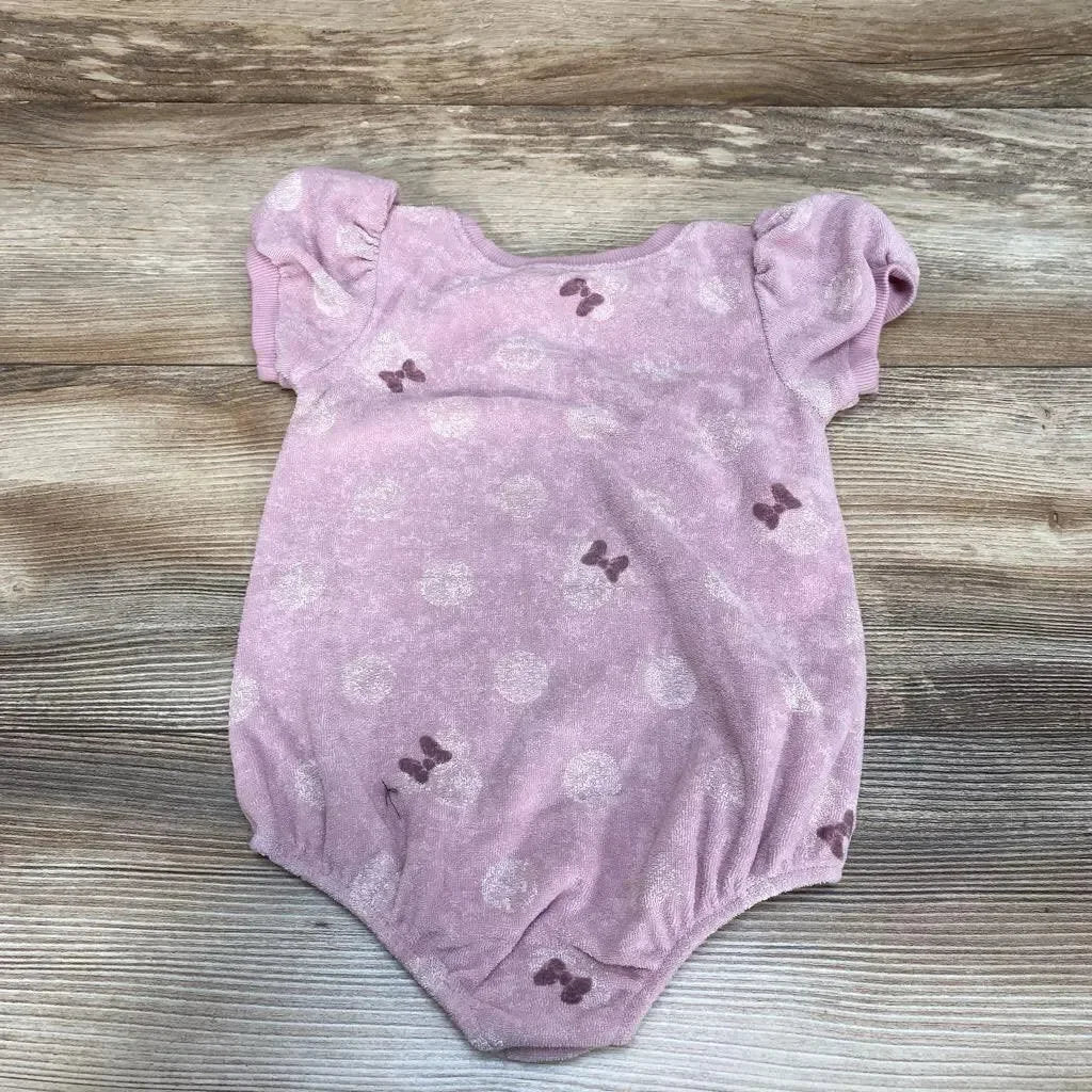 Flat-lay of purple Minnie Mouse terry romper 18m showing puff sleeves, bow print and elastic legs on wood