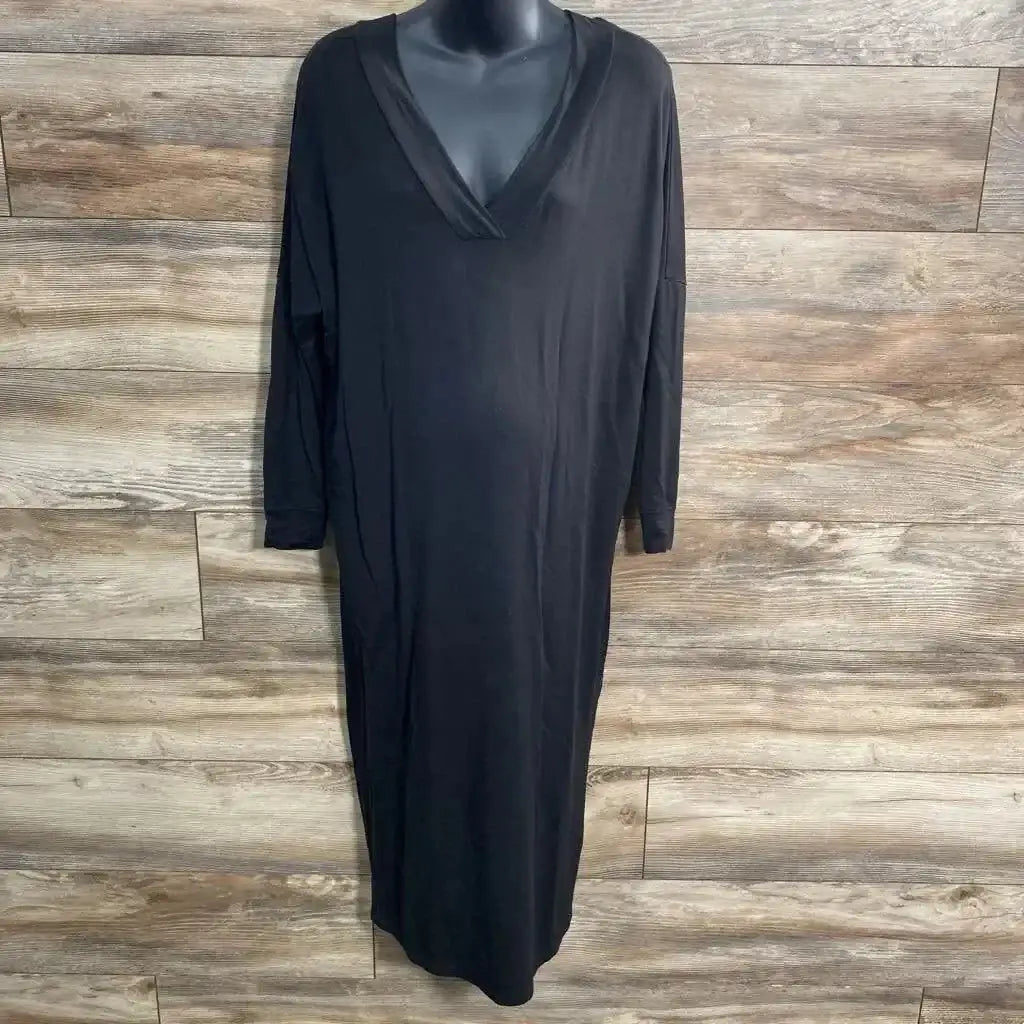 Front view of black Quince maxi dress on mannequin showing V-neck, long sleeves, relaxed ankle-length fit on wood background