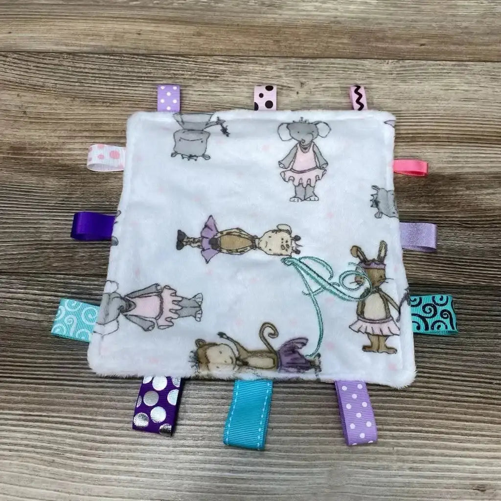 Top-down view of pink crinkle square with colorful ribbon tabs and animal print on a wooden surface