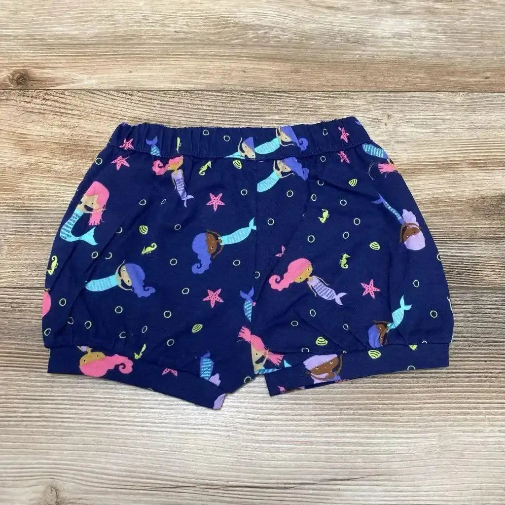 Flat lay of NEW Okie Dokie Mermaid Bubble Shorts sz 12m in navy with colorful mermaid seahorse and starfish print and elastic waist on wood plank floor