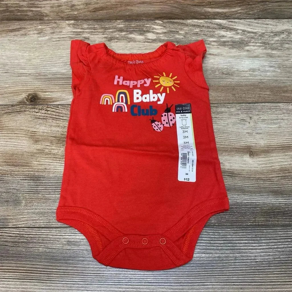 Flat lay of red Okie Dokie 3M baby bodysuit showing 'Happy Baby Club' print, ruffled sleeves and price tag on wood