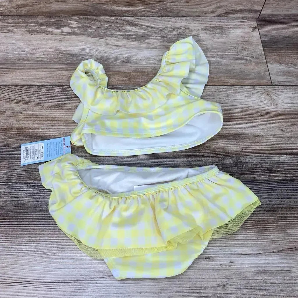 Top-down view of yellow gingham 2-piece toddler bikini size 5T with ruffle-trim top and layered ruffle bottoms on wood floor