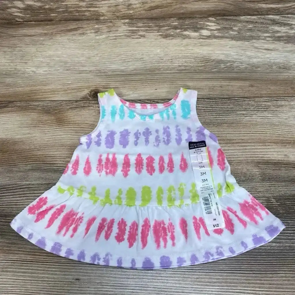 Flat lay of NEW Okie Dokie Tie-Dye Tank Top in white with pink purple and green tie-dye stripes and hangtag on wood floor
