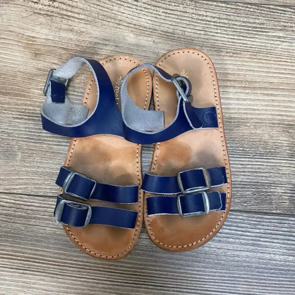 Top-down view of navy Freshly Picked Rockaway toddler sandals size 8c showcasing two front buckles and ankle strap with wood floor background