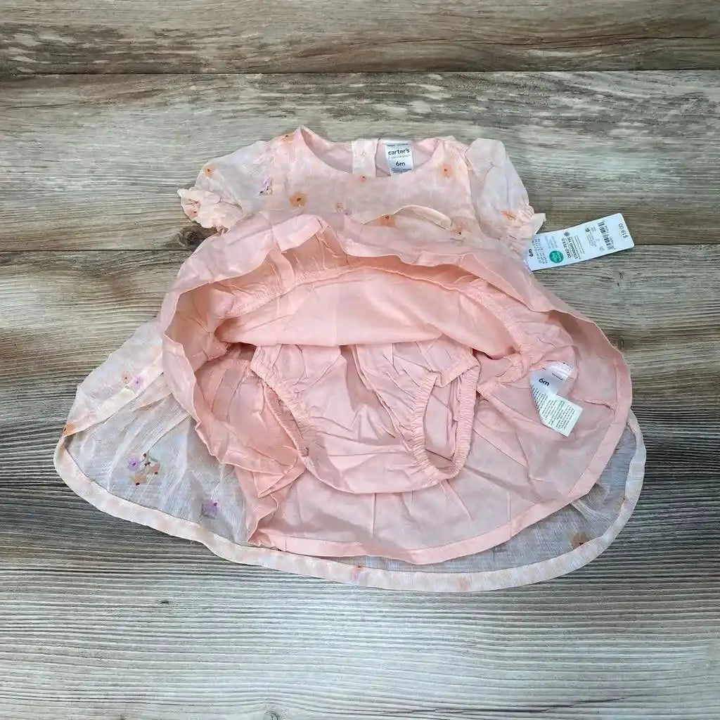 Flat lay of Just One You two piece set with peach floral short sleeve dress flipped showing matching bloomers and hangtags on wood plank floor