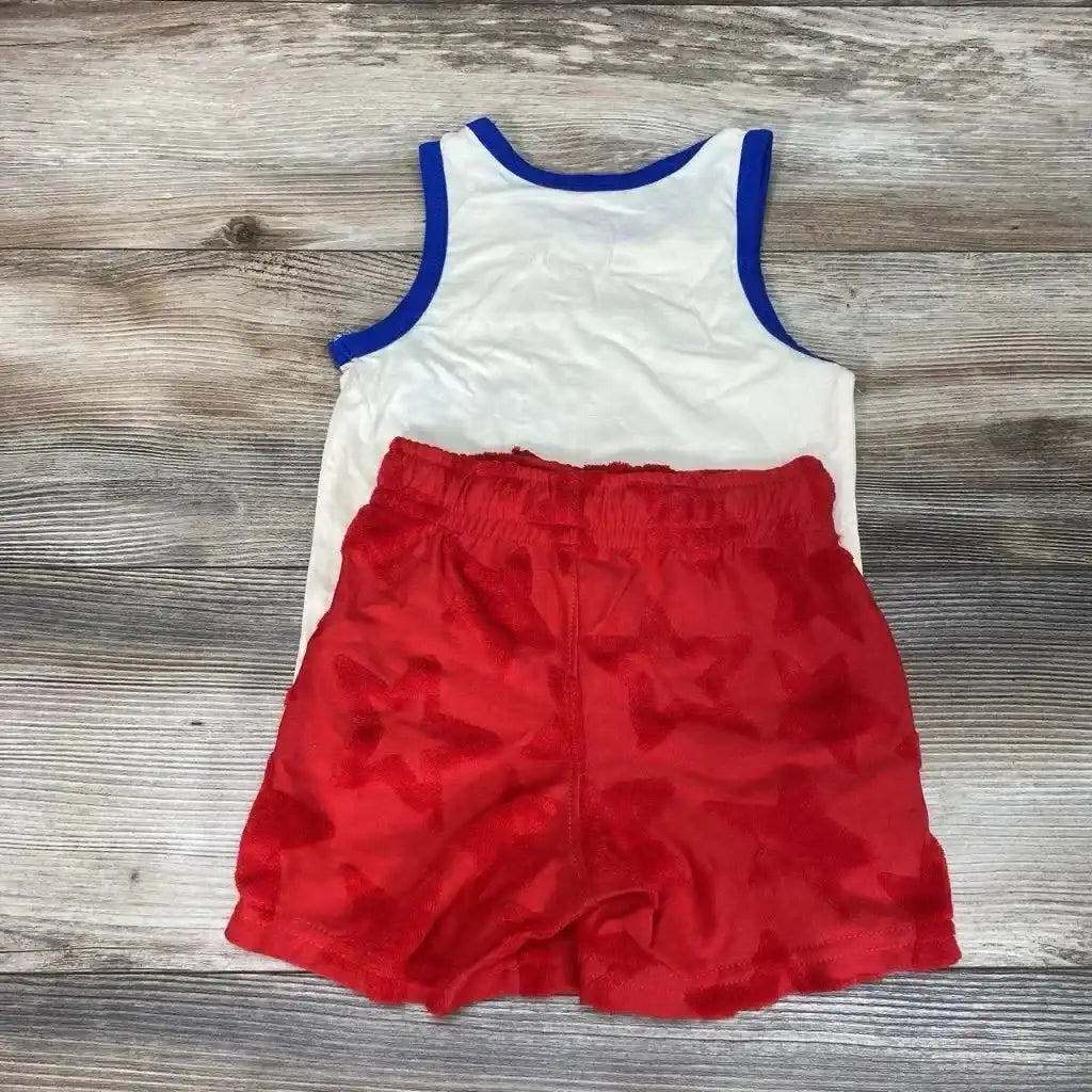 Flat lay of toddler 2-piece tank and shorts 3T showing white tank with blue trim and red star-print shorts on wood