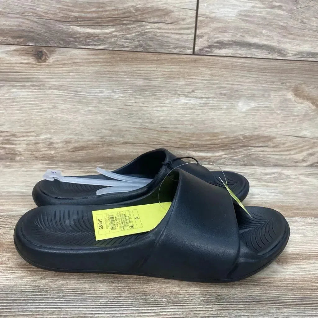 Side view of black All in Motion Apollo slip-on slide sandals size 6Y showcasing contoured textured footbed and wide strap on wood floor background