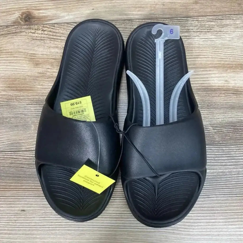 Overhead of black All in Motion Apollo slides size 6Y showing contoured footbed and wide strap on wood floor