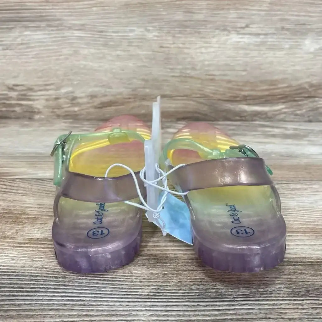 Back view of Cat and Jack children's yellow iridescent jelly sandals, size 13, translucent purple soles on wood surface