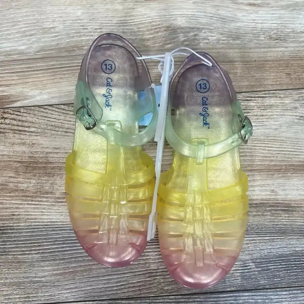 Top view of Cat & Jack jelly sandals in yellow-to-pink ombre with buckle ankle straps, size 13c, on wood background