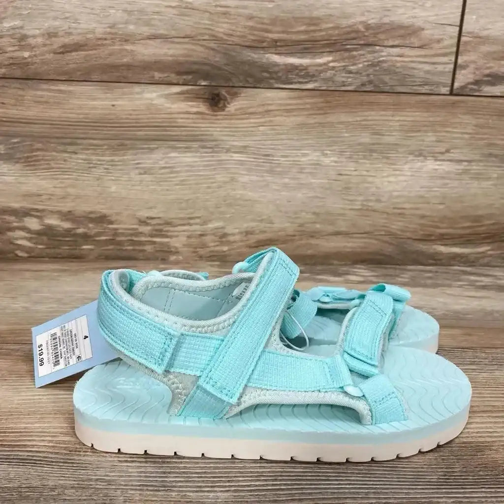 Side view of turquoise Cat & Jack Emery toddler sandals showcasing adjustable ankle and toe hook-and-loop straps on wood-plank background