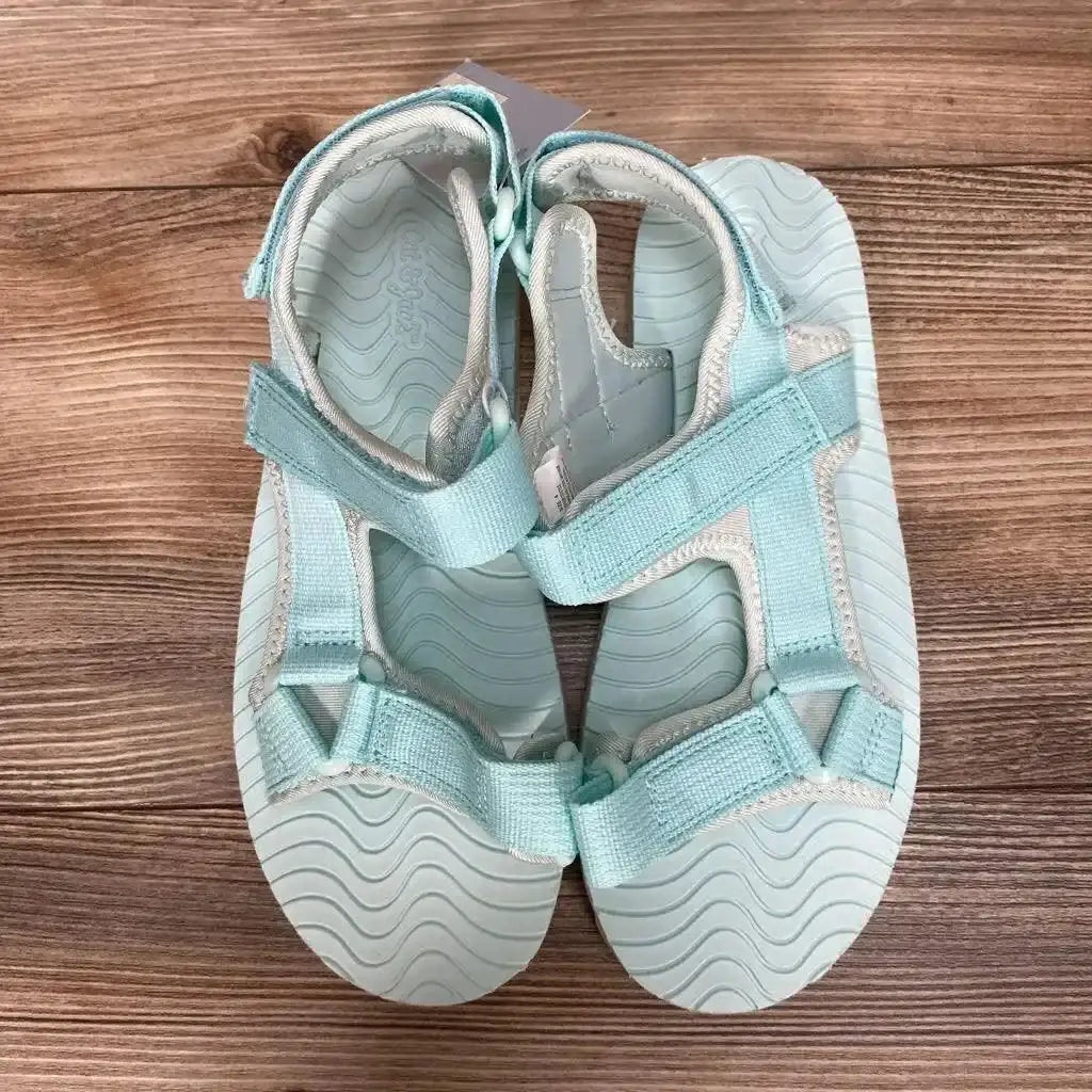 Top view of Cat & Jack Emery toddler ankle-strap sandals, turquoise size 4Y, adjustable Velcro straps on wood background