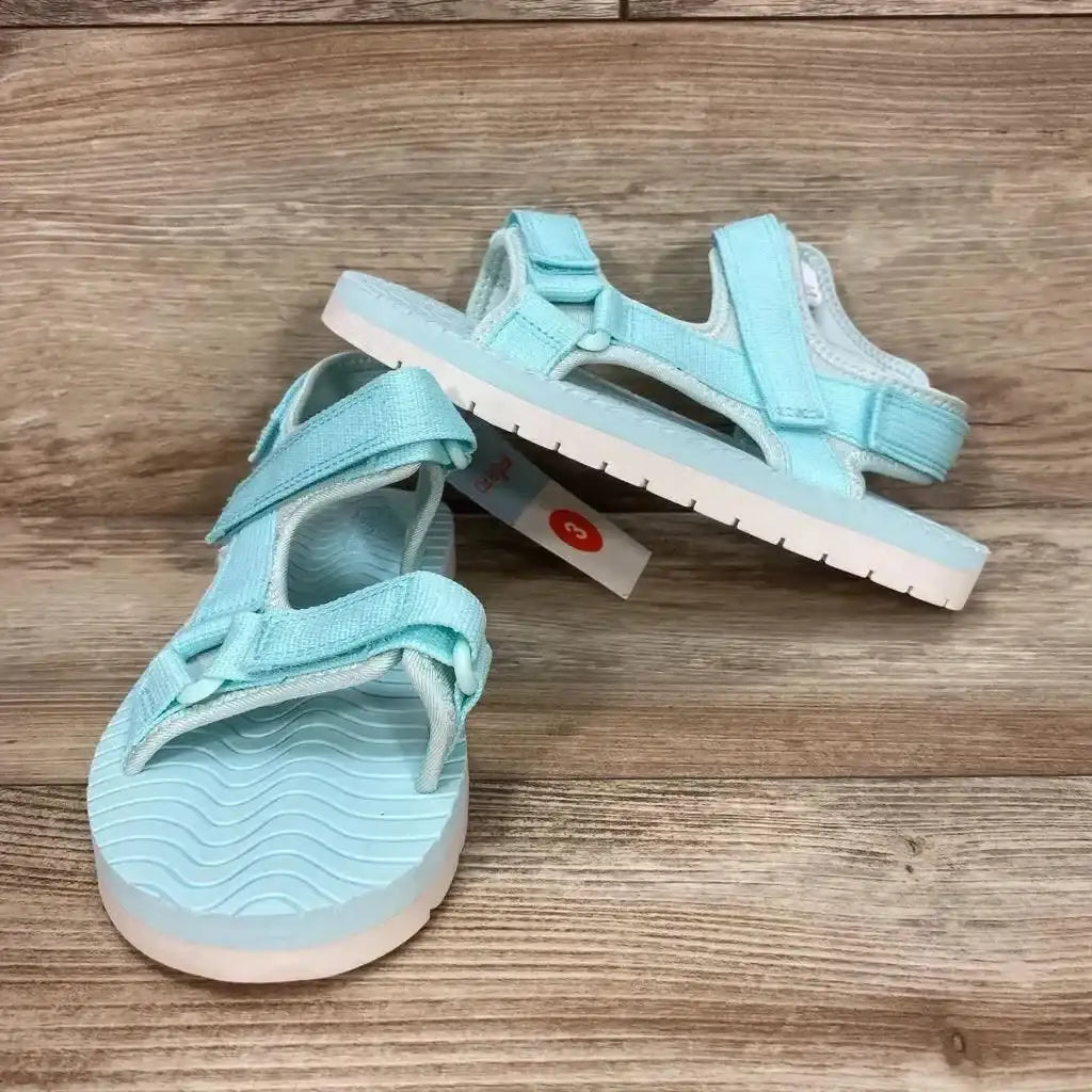 Three-quarter view of Cat & Jack Emery sandal, turquoise, showing velcro ankle straps and wavy footbed on wood surface