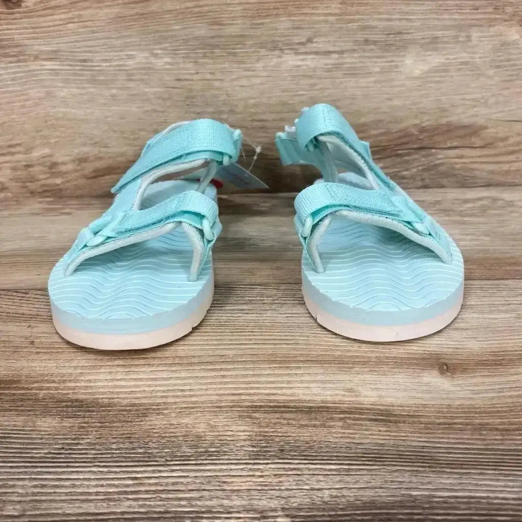Front view of turquoise Cat & Jack Emery toddler sandals showcasing adjustable ankle and toe straps on wood background