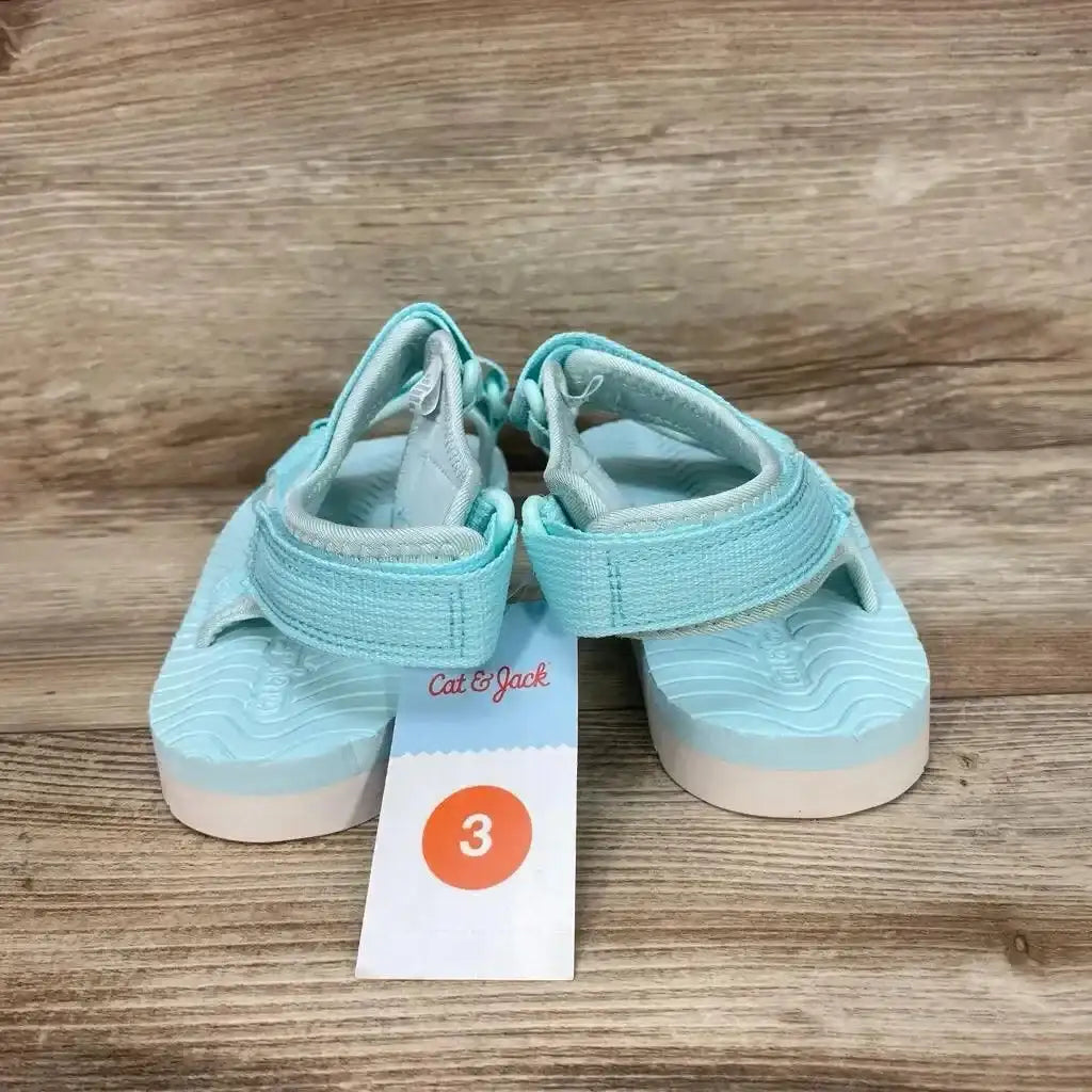 Front view of turquoise Cat & Jack sandals size 3Y showing Velcro straps and molded sole on wood floor