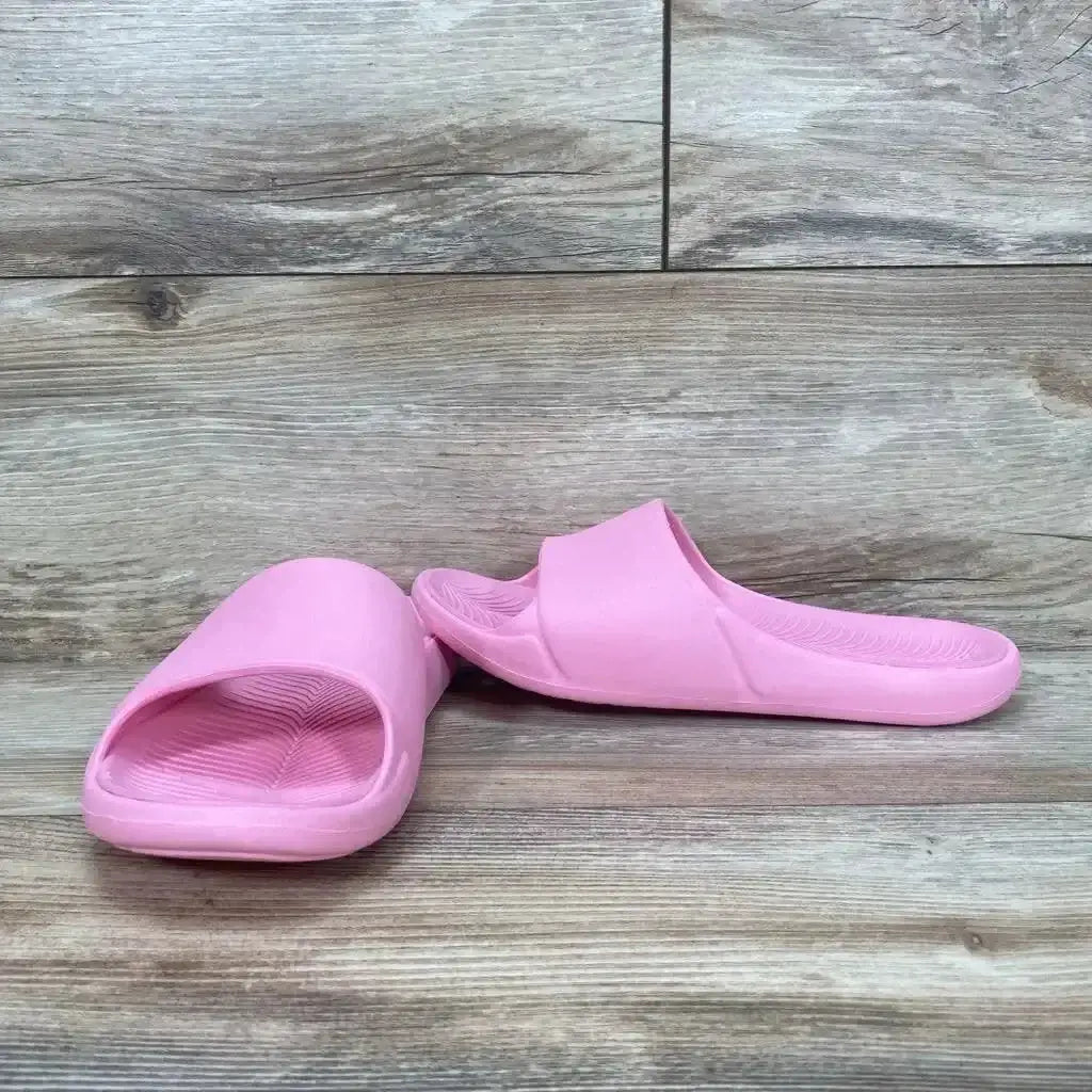 Front three-quarter view of pink All in Motion Apollo slide sandal size 5Y showing ribbed footbed and wide strap on wood background