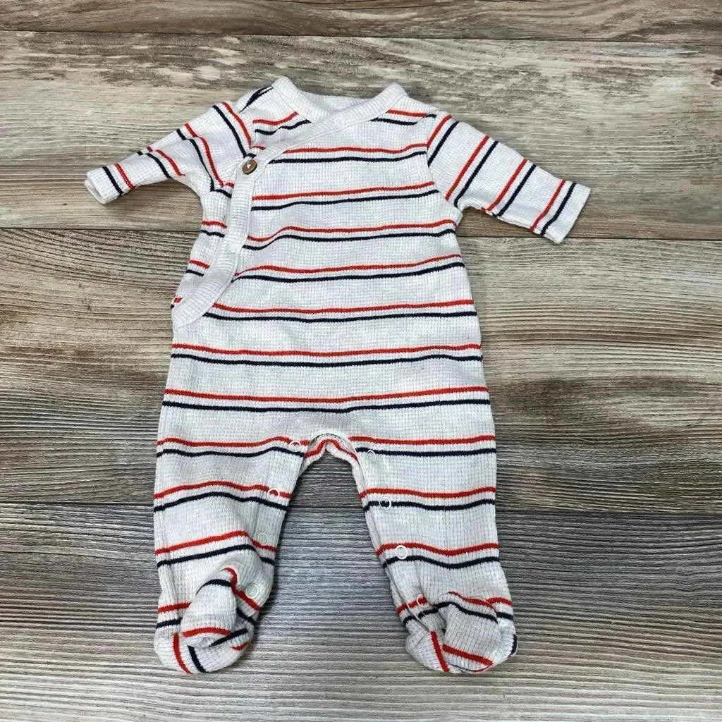 Top-down view of preemie oatmeal footed sleeper with navy and red stripes and side snap closure on wood background