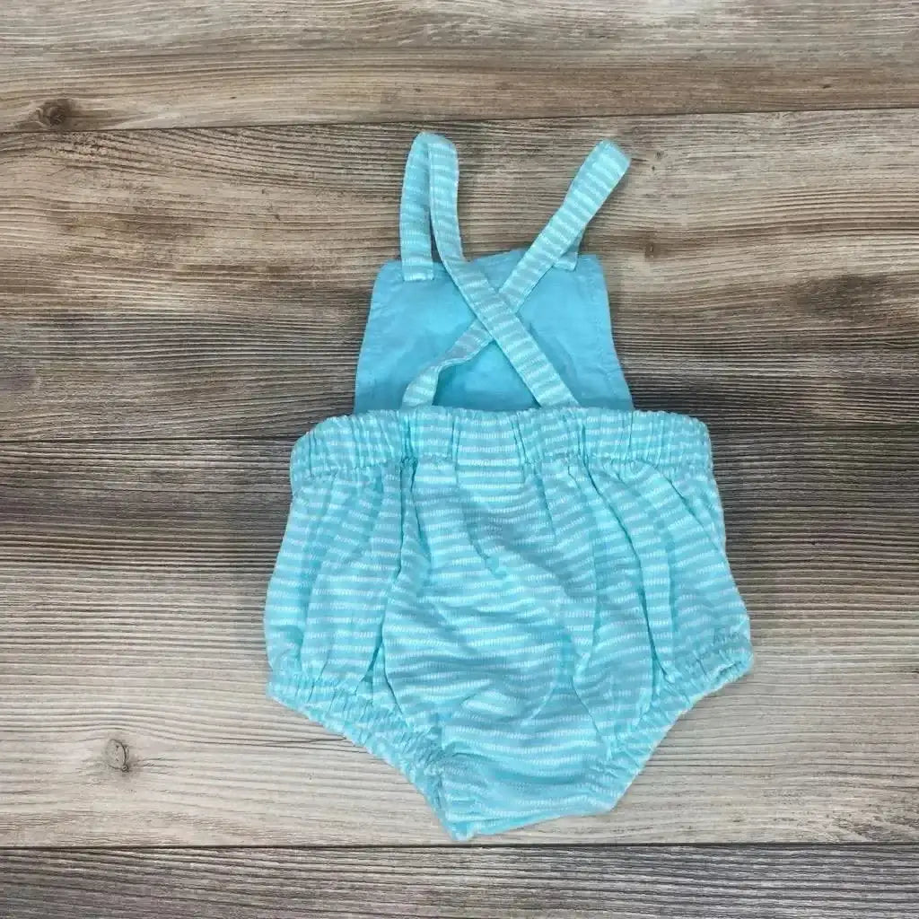 Top-down of blue striped Cat and Jack romper 0-3M with cross-back straps and elasticized waist and leg openings on wood