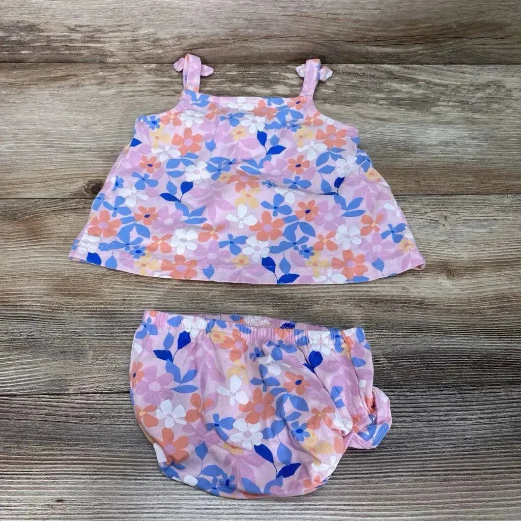Flat lay of Carter's pink 2-piece floral top and matching bloomers showcasing pastel multicolor flower print on wood background