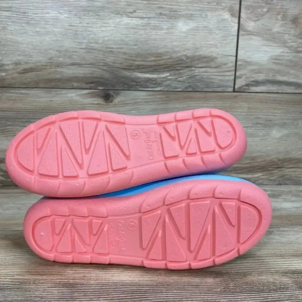 Bottom view of Cat & Jack Andy slip-on rain boots size 6Y showing pink tread soles on wood floor