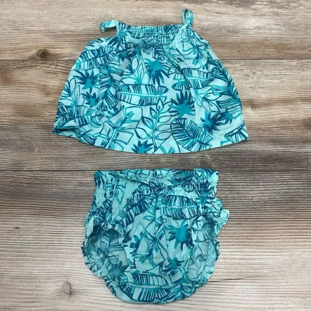 Top-down of Carter's blue tropical baby top and bloomers with elastic waist, ruffled legs, and tie strap on wood