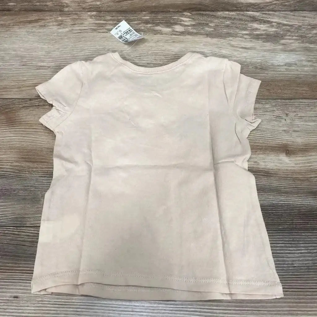 Back view of NWT Children’s Place pink graphic shirt sz 18-24m showcasing short sleeves and visible hangtag on wood plank background