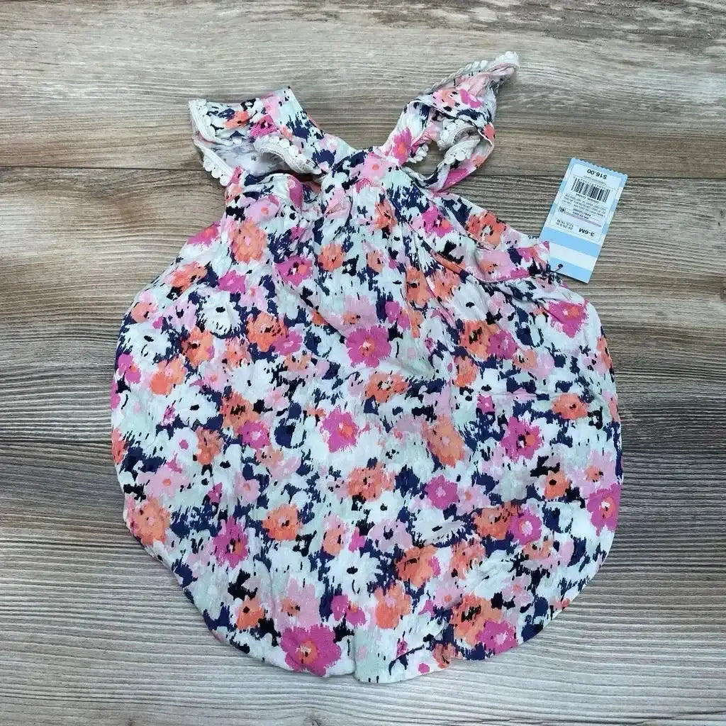 Flat lay of Cat & Jack floral romper (3-6 months) showing flutter sleeves and pink, orange, navy print on wood background