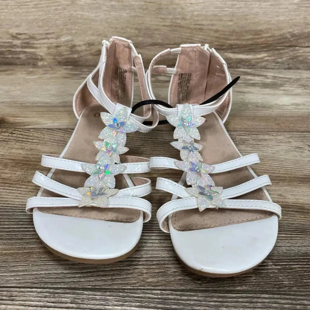 Front view of white toddler sandals (size 3Y) showcasing iridescent flower T-strap embellishments and ankle straps on wood floor