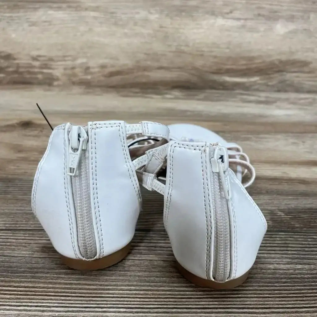 Rear view of white New So Tangelo toddler sandals, size 3Y, showing back zippers and braided straps on wood background